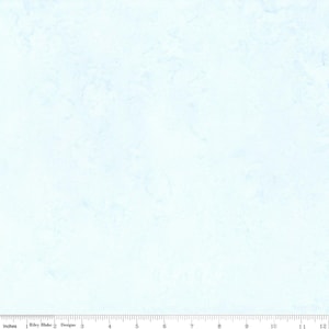 May include: Light blue fabric with a subtle, textured pattern. The fabric has a watercolor-like appearance, with soft, blended shades of blue. The image includes a ruler along the bottom edge, with markings in inches.