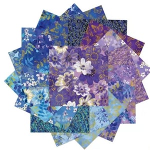 May include: A collection of square fabric swatches arranged in a starburst pattern, featuring various shades of blue and purple. The designs include floral prints, butterfly motifs, and marbled patterns with gold-toned accents on cotton fabric.