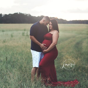 The Aphrodite strapless maternity gown is fitted in a mermaid design that flares at the bottom in a long train. Perfect for special occasions, the soft knit dress hugs your curves and bump in all the right places. Comes in many colors & plus sizes.