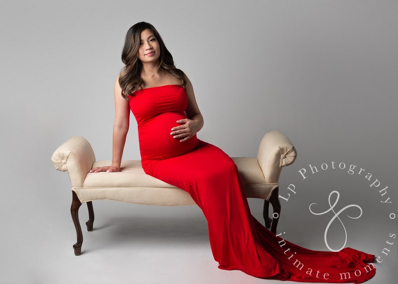 The Aphrodite strapless maternity gown is fitted in a mermaid design that flares at the bottom in a long train. Perfect for special occasions, the soft knit dress hugs your curves and bump in all the right places. Comes in many colors & plus sizes.