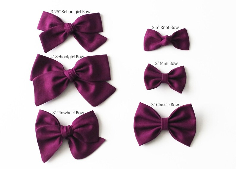 May include: Five different sizes of burgundy fabric hair bows. The bows are labeled with their size and type: 3.25" Schoolgirl Bow, 4" Schoolgirl Bow, 2.5" Knot Bow, 2" Mini Bow, 3" Classic Bow, and 3" Pinwheel Bow.