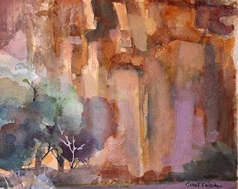 May include: A watercolor painting depicting a towering orange and brown canyon wall with vertical rock formations. Green and purple foliage is visible at the base and foreground. The artist's signature, Giuffrida, is written in the lower right corner.