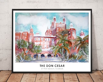 May include: Watercolor painting of The Don CeSar hotel in St. Pete Beach, Florida, framed in black. The artwork depicts the pink hotel with palm trees and a blue sky. The text "THE DON CESAR" and "ST PETE BEACH, FLORIDA" are at the bottom.