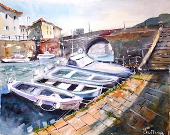 May include: Watercolor painting of a harbor scene with several small boats docked along a brick pier. Buildings with orange roofs and a stone bridge are in the background. The water reflects the boats and buildings. The painting is signed in the lower right corner.