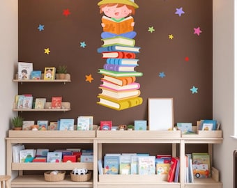 May include: A brown wall with a colorful sticker of a child sitting on a stack of books. The child is wearing a hat and reading a book. There are colorful stars on the wall. The wall has two wooden shelves with books on them.