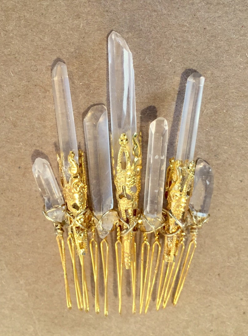 May include: Gold hair comb with clear quartz crystals attached. The crystals are set in gold filigree.