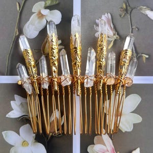 May include: A gold-colored hair comb adorned with clear quartz crystals. The comb features a series of gold-toned prongs, with each prong supporting a crystal. The crystals are of varying sizes and shapes, adding to the comb's unique design.