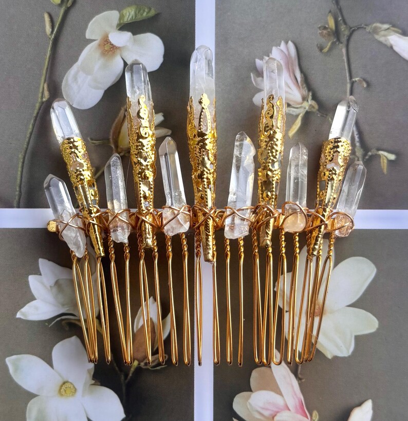 May include: A gold-colored hair comb adorned with clear quartz crystals. The comb features a series of gold-toned prongs, with each prong supporting a crystal. The crystals are of varying sizes and shapes, adding to the comb's unique design.