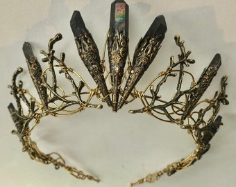 May include: A gold wire crown with black crystal points and a branch-like design. The crown is made of wire and has a delicate, intricate design.