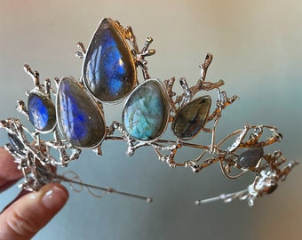 May include: A silver crown with a delicate branch design and iridescent blue labradorite stones.