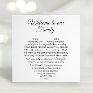 May include: A white wedding card with black script. The card reads "Welcome to our Family" at the top, followed by a poem welcoming a new family member. The word "Daughter" is in a cursive font.