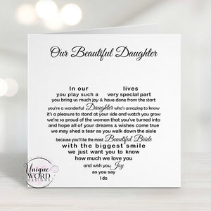 May include: A white greeting card with the text "Our Beautiful Daughter" in elegant script. The card contains a heartfelt message about a daughter's wedding, with the words arranged in a heart shape. The card is from Unique Word Designs.