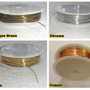 Puede incluir: Cuatro carretes de alambre en diferentes acabados: latón antiguo, cromo, latón y cobre. Cada carrete está en una base de plástico blanco.