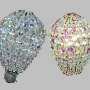 May include: Two iridescent clear glass bulb covers with a wire frame. The covers are made of small round beads and are designed to be used as a light fixture.