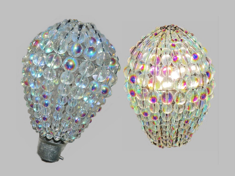 May include: Two iridescent clear glass bulb covers with a wire frame. The covers are made of small round beads and are designed to be used as a light fixture.