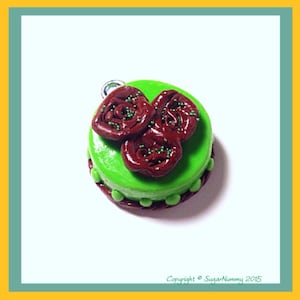 May include: A green cake with brown frosting and green sprinkles. The cake is decorated with three brown swirls of frosting.