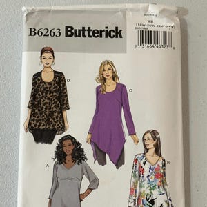 Pode incluir: Um envelope de padrão de costura Butterick, B6263, com ilustrações de quatro modelos de túnicas. O envelope é branco com o logotipo Butterick e informações de tamanho. Os tops têm diferentes decotes e comprimentos de manga.