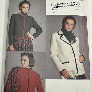 May include: Vogue Patterns 9382 sewing pattern envelope for sizes 12-14-16. The front displays three jacket variations: a dark green jacket with red trim, a red jacket with black trim, and a cream jacket with black trim, all featuring buttons.