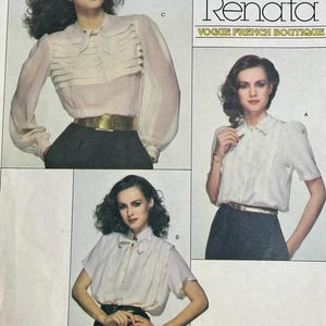 May include: A sewing pattern envelope for Vogue French Boutique Renata design 2185, featuring illustrations of three variations of a blouse. The blouses are light-colored with collars, tie-neck details, and short or long sleeves, paired with dark skirts.