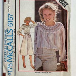 May include: Vintage McCall's 6157 sewing pattern for a Misses' dress or top. The pattern features a drawing of a woman wearing a dress with a belted waist and a woman wearing a striped blouse. The pattern is labeled "Quick & Easy".