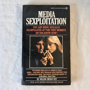 May include: A vintage paperback book titled "Media Sexploitation" with a black cover. The cover features a couple smoking cigarettes and the text "You are being sexually manipulated at this very moment. Do you know how?"