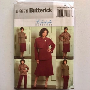 May include: A Butterick B4878 sewing pattern for a Lifestyle Wardrobe. The pattern features a woman in a burgundy suit with a cape, and other outfits in brown and burgundy. The pattern size is (26W-32W).