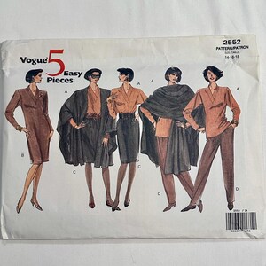 May include: Vogue Easy Pieces sewing pattern number 2552 for sizes 14-16-18. The pattern includes four different looks featuring a brown dress, a brown skirt and top, a brown top with a black cape, and a brown top with brown pants.