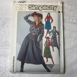 May include: Simplicity sewing pattern showing a woman in a floral shirt, denim skirt, and cowboy hat. The pattern includes various outfit options. The package is labelled with the brand name and size details.