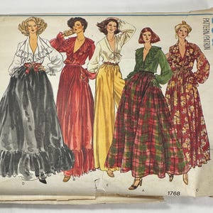 May include: A vintage Vogue's Basic Design sewing pattern envelope, number 1768, featuring illustrations of five different outfits including long skirts, wide-leg trousers, and blouses with ruffles, rendered in various colors like black, red, yellow, and plaid.