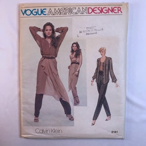 May include: Vintage Vogue American Designer sewing pattern featuring Calvin Klein designs. The pattern cover displays illustrations of women's clothing, including a wrap skirt, pants, and a jacket. The cover has the text "Vogue American Designer" and "Calvin Klein".