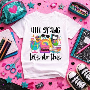 May include: White t-shirt with the text "4th Grade let's do this" and a colorful graphic of school supplies, including a tie-dye backpack. The backpack has the name "Hadley" on it. The shirt is surrounded by school supplies and accessories.