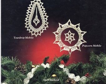 May include: Three white crocheted ornaments, a teardrop, a snowflake, and a popcorn design, are displayed on a dark background with a green garland below. The text "Wondrous Mobiles..." is at the top of the image. The text "Teardrop Mobile" is below the teardrop ornament. The text "Popcorn Mobile" is below the popcorn ornament. The text "Shell Garland" is below the garland.