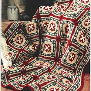 Może przedstawiać: Ręcznie robiony koc z dzianiny z geometrycznym wzorem w odcieniach czerwieni, bieli, beżu i szarości.