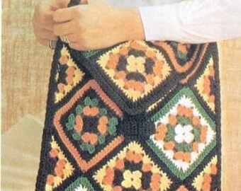 Può includere: Una borsa a tracolla all'uncinetto composta da molteplici motivi quadrati con un disegno geometrico in nero, giallo, arancione e verde. La borsa presenta una chiusura a patta ripiegabile e una tracolla all'uncinetto nera, con un design in filato.
