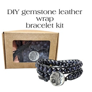 May include: DIY gemstone leather wrap bracelet kit in a brown box. The bracelet is made of black leather and blue gemstone beads with a silver moon and star charm.