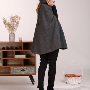 May include: A gray hooded cape with a long, flowing design. The cape is made of a soft, warm fabric and is perfect for keeping you cozy on chilly days.