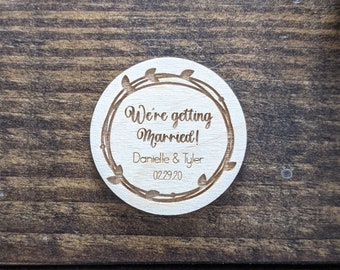 Round wood save the date magnet we're getting married with names and date