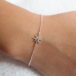 May include: A silver chain bracelet with a star-shaped charm.