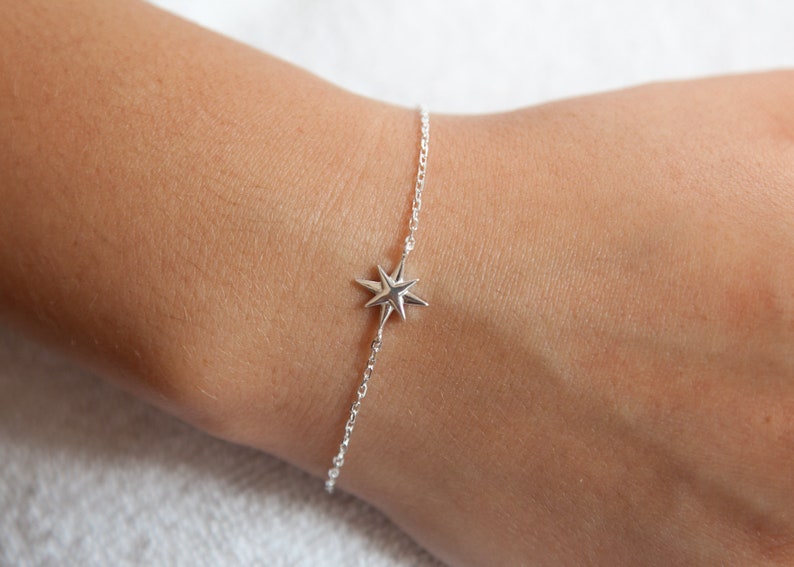 May include: A silver chain bracelet with a star-shaped charm.