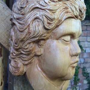 A hand carved figure of a Cherub or Angel type head.
