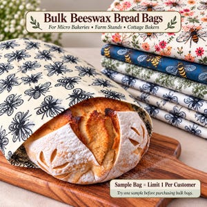 Pode incluir: Um pão estaladiço dentro de um saco de cera de abelha com padrão de abelhas pretas. Atrás, uma pilha de sacos dobrados com estampados florais e de abelhas. O texto diz: Bulk Beeswax Bread Bags For Micro Bakeries, Farm Stands, Cottage Bakers.