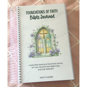 May include: A spiral-bound Bible journal with the title "FOUNDATIONS OF FAITH Bible Journal." The cover features a watercolor illustration of a church window with a cross, surrounded by flowers. The text reads "A Daily Bible Reading & Devotional Journal for Faith, Renewal, New Beginnings, and Daily Reflection."