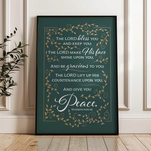 Könnte beinhalten: Ein gerahmter Druck mit dunkelgrünem Hintergrund und goldfarbenen dekorativen Elementen. Der Text lautet "The Lord bless you and keep you...and give you Peace. Numbers 6:24-26" in verschiedenen Schriftarten. Der Rahmen ist schwarz.