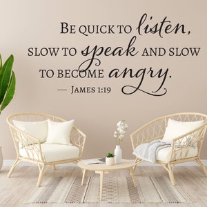 May include: A beige wall with a black vinyl wall decal that reads "Be quick to listen, slow to speak and slow to become angry. - James 1:19". The decal is above two wicker chairs with white cushions. A small potted plant sits on a wooden coffee table between the chairs.