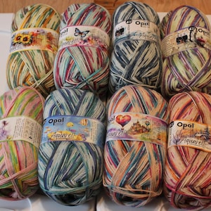 May include: Ten balls of Opal Aquarell yarn in various color combinations. Each ball features a different watercolor-style design on the label.