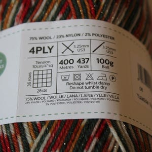 May include: A ball of 4-ply yarn with a label that reads "Perfect for Socks." The yarn is a mix of red, green, gold, and white. The label includes details about the yarn's composition, weight (100g), and length (437 yards).