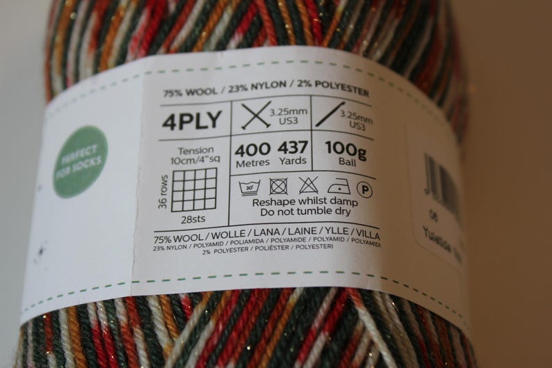 May include: A ball of 4-ply yarn with a label that reads "Perfect for Socks." The yarn is a mix of red, green, gold, and white. The label includes details about the yarn's composition, weight (100g), and length (437 yards).