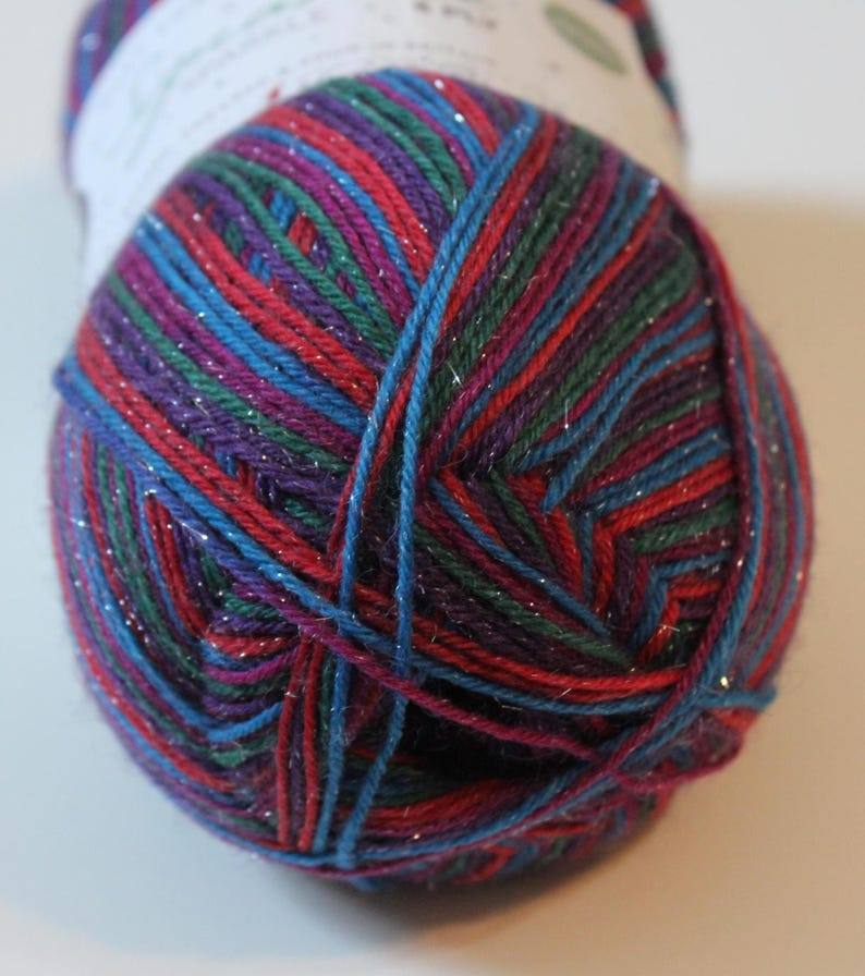 May include: A ball of colorful yarn with a mix of red, blue, purple, and green strands. The yarn has a subtle shimmer, adding a touch of sparkle. Ideal for knitting or crocheting projects.