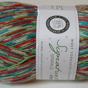 May include: A ball of colorful yarn with red, green, blue, and pink strands, with a label that reads "Signature Sparkle". The yarn contains 75% wool and 35% Bluefaced Leicester. Ideal for knitting and crochet projects.