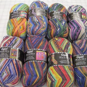 May include: A collection of Opal brand yarn skeins, each labeled 100 g and 425 m. The yarn features a variety of colors, including blue, green, yellow, red, and purple, creating a vibrant, striped pattern. The skeins are neatly arranged.